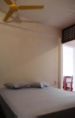 a bedroom with a bed with a ceiling fan at Paz Apartment in Mindelo