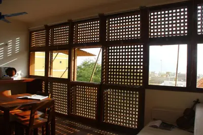 a room with a wall of windows with a desk and a table at Paz Apartment in Mindelo