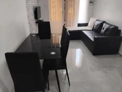 a living room with a black couch and a table at Apartamento em Pedra Badejo in Pedra Badejo