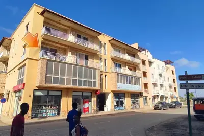 a building on a street with people standing in front of it at Modern apartment in the Center in Sal Rei