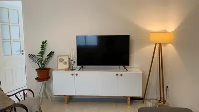 a television on a white cabinet in a living room at Flat Mindelo 30 in Mindelo