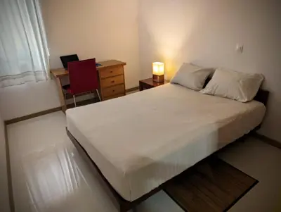 a bedroom with a bed with a desk and a chair at Vila Prainha in Praia