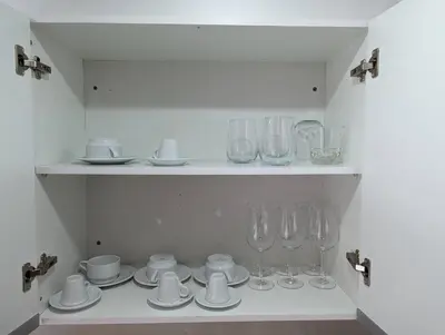 a shelf with glasses and cups and plates on it at Vila Prainha in Praia