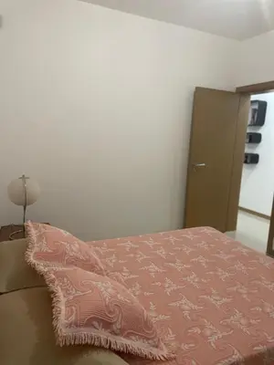 a bedroom with a bed with a pink blanket on it at Meraki's Apartment in Praia