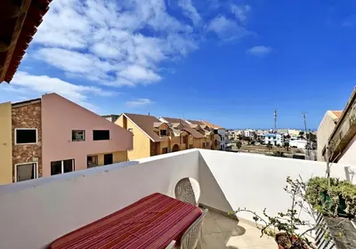 a balcony with a bench on a white wall at Bright Top Floor with Terrace in Santa Maria