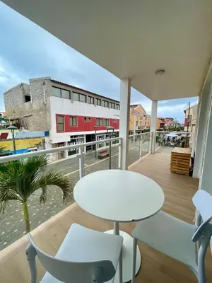 a white table and chairs on a balcony with a building at Mota Residência in Santa Maria