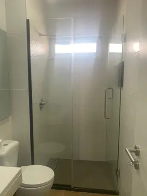 a bathroom with a glass shower with a toilet at Mota Residência in Santa Maria