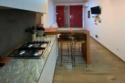 a kitchen with a stove and some bar stools at A Baia do Fortim in Mindelo