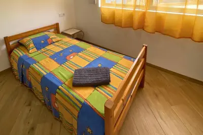a bed with a colorful comforter in a bedroom at A Baia do Fortim in Mindelo