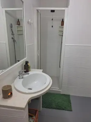 a white bathroom with a sink and a shower at Apart Santa Maria in Santa Maria