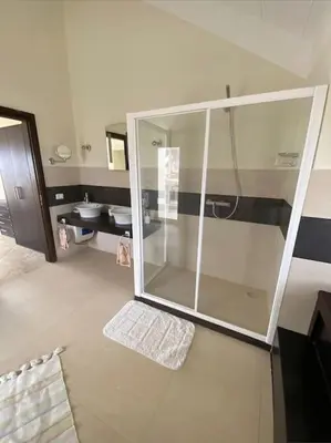 a bathroom with a glass shower and a sink at Surf House - Your Exclusive Getaway in Palmeira