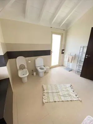 a large bathroom with two toilets and a window at Surf House - Your Exclusive Getaway in Palmeira