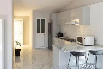 a kitchen with white cabinets and a counter with stools at 2 bdr cozy apartment in city center, Wifi - LCGR in Assomada