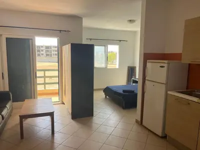 a kitchen with a refrigerator and a table in a room at Central Studio Apartment near beach in Santa Maria