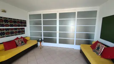 a living room with two couches and a large window at Albis Harena - Leme Bedje Residence in Santa Maria