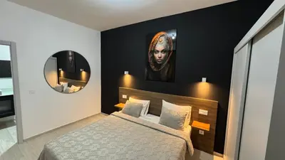 a bedroom with a bed and a portrait of a woman at CasaZina in Tarrafal