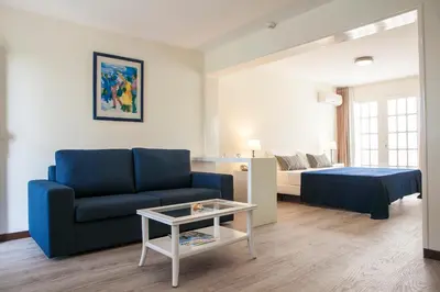a living room with a couch and a bed and a table at Murdeira Village in Beirona