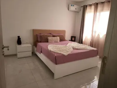 a bedroom with a bed with purple sheets and a window at Appartement standing praia in Praia