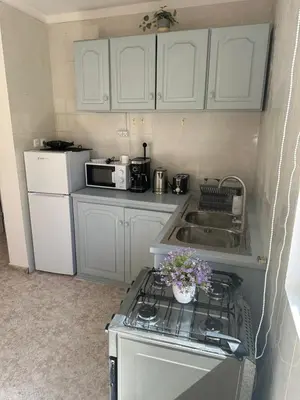 a kitchen with white cabinets and a stove and a sink at Coração de Santa Maria in Santa Maria
