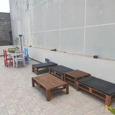 a room with benches and a table and chairs at Casa fréd in Mindelo