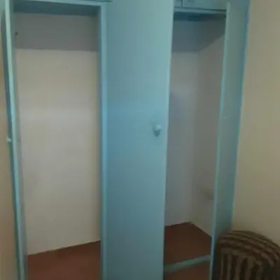 a closet with blue glass doors and a chair at Padaria Portuguesa, with porch facing the street in Santa Maria