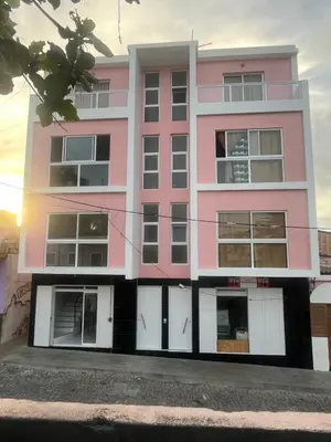 a pink building with white doors and windows at Oásis de retour in Ponta do Sol