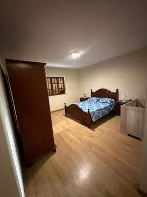 a bedroom with a bed and a wooden floor at Casa Lima in Mindelo