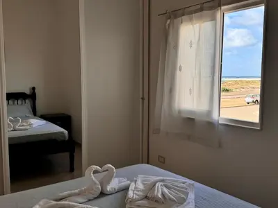 a bedroom with two swans on a bed with a window at Sea view - Ca Mauro - Praia Cabral - Wi-Fi in Sal Rei