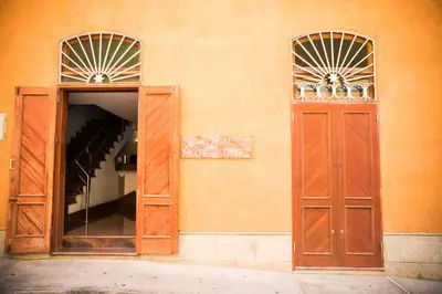 an orange building with two doors and a mirror at Royal Mindelo Suite in Mindelo