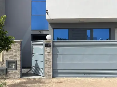 a blue garage door on a house at Chez Lena, Appartement confortable 3 chambres in Praia
