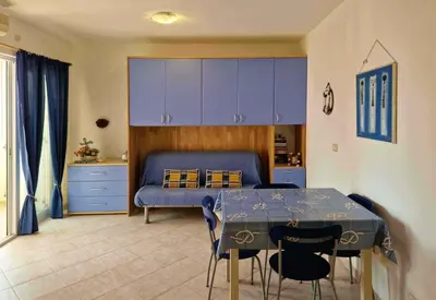 a bedroom with a bed and a table and blue cabinets at Tommy's Apartment in Santa Maria