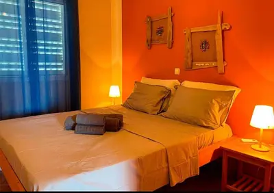 a bedroom with a large bed with orange walls at Garoupa Stella Maris Apartamento N10 in Vila do Maio