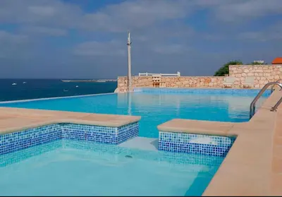 a large swimming pool with blue water at Garoupa Stella Maris Apartamento N10 in Vila do Maio