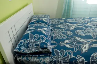 a bed with blue and white sheets and pillows at FADIAS Quartos - Rooms in Ribeira Grande