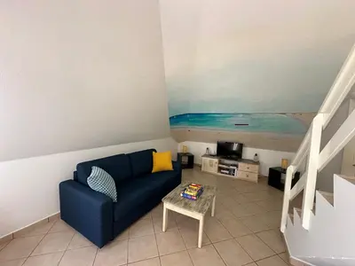a living room with a blue couch and a table at FantaSea Apartment Leme Bedje in Santa Maria
