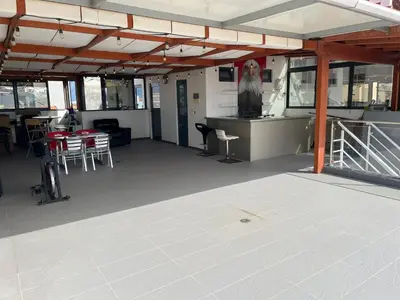 a large room with a table and chairs on a boat at Apto Duarte T1 Compacto in Praia
