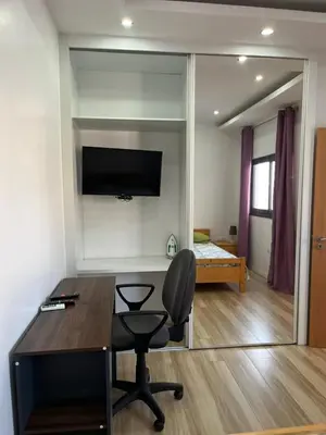 a room with a desk and a chair and a mirror at Apto Duarte T1 Compacto in Praia