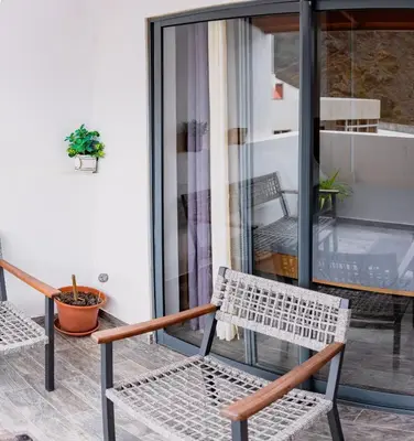 a patio with two chairs and a table and a window at Apartamentos Modernos Santo Antão in Ribeira Grande