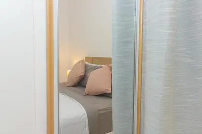 a reflection of a bed with pillows in a mirror at Brand New Spacious T3 Apartment in Santa Maria in Santa Maria