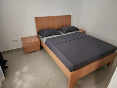 a bedroom with a bed with a wooden headboard at DMSilva in Praia