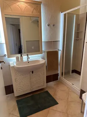 a bathroom with a sink and a mirror and a shower at Tropical Paradise in Santa Maria