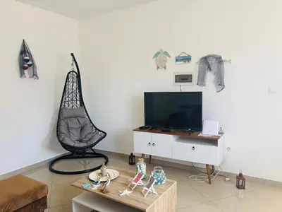a living room with a tv and a table at Techas Stylish 2-Bedroom 8 min to Beach in Tarrafal