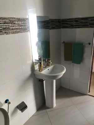 a white bathroom with a sink and a shower at Techas Stylish 2-Bedroom 8 min to Beach in Tarrafal