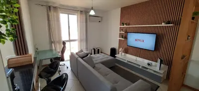 a living room with a couch and a flat screen tv at Sinta-se em casa! in Praia