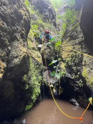 a person on a rope bridge over a river at Casa Branca in Ponta do Sol