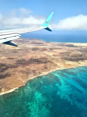 an airplane wing flying over a body of water at Bayview Bliss Appartement in Santa Maria