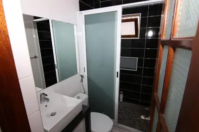 a bathroom with a sink and a toilet and a shower at Kasa Tabuga in Porto Novo