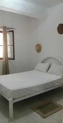 a white bed in a white room with a window at Sunset Plateau in Praia