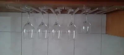 a group of wine glasses hanging from a wall at Sunset Plateau in Praia