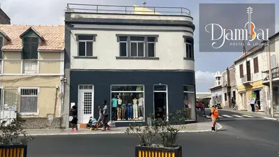 a store on the side of a street with a building at Hostel Djambai in Mindelo